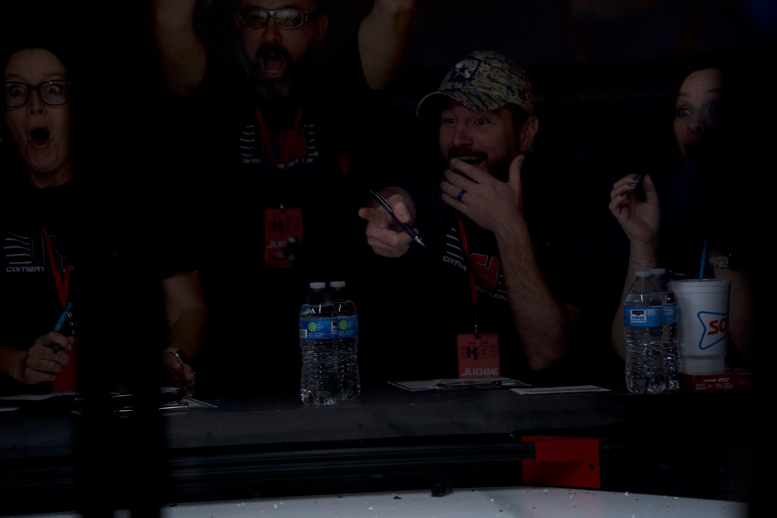 Judges and volunteers reacting with genuine energy during a Kilobots match
