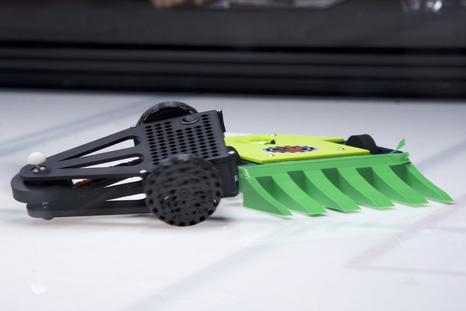A 3D-printed Kilobots robot with a colorful printed weapon attachment